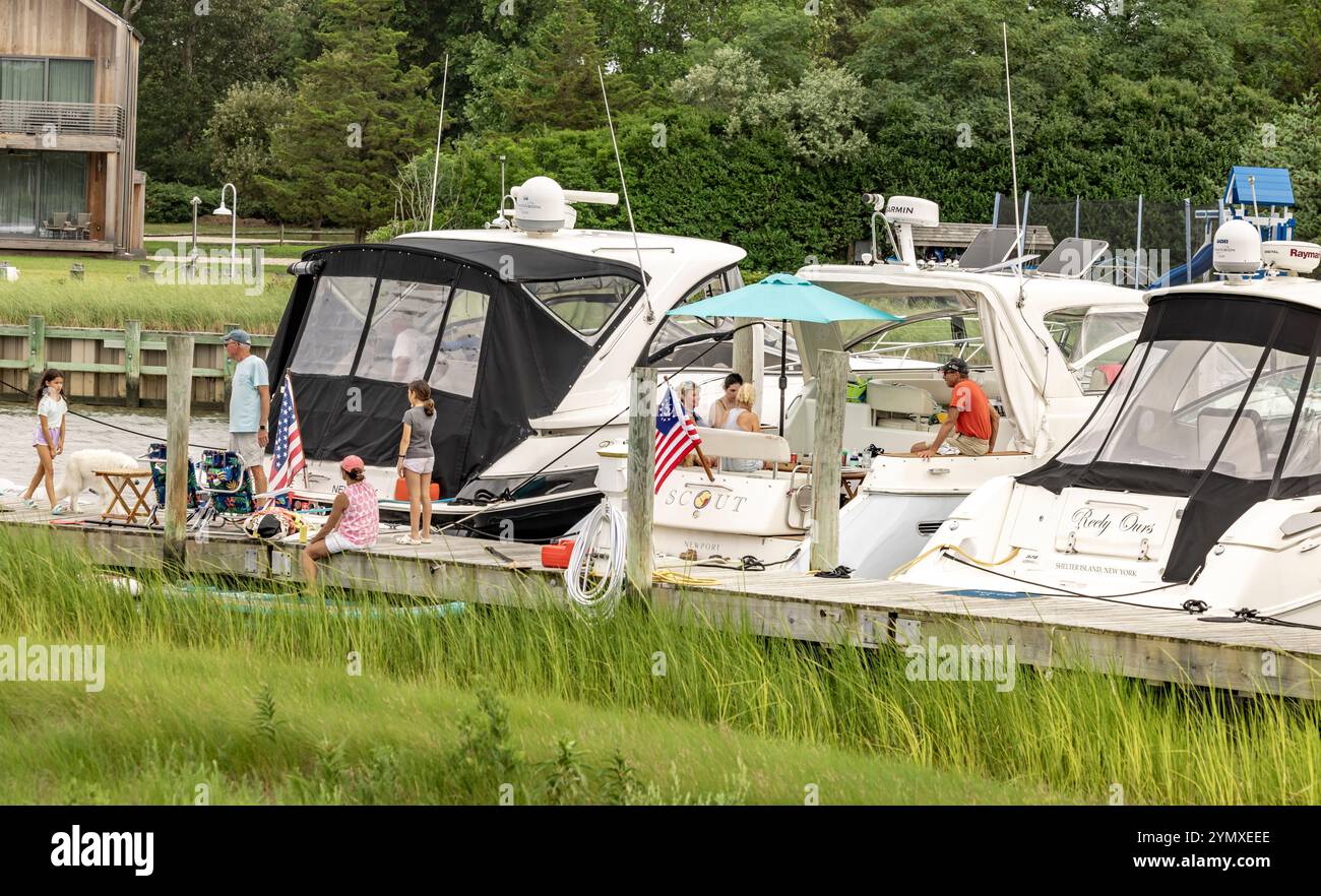 gente che si diverte a stare in giro sul retro delle proprie barche al cantiere delle barche dell'isola Foto Stock