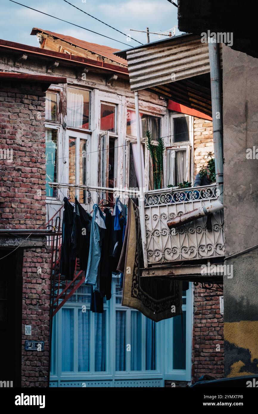 Asciugatura della biancheria su un vecchio balcone in procinto di crollare nel quartiere di Kala, nella città vecchia di Tbilisi, in Georgia Foto Stock