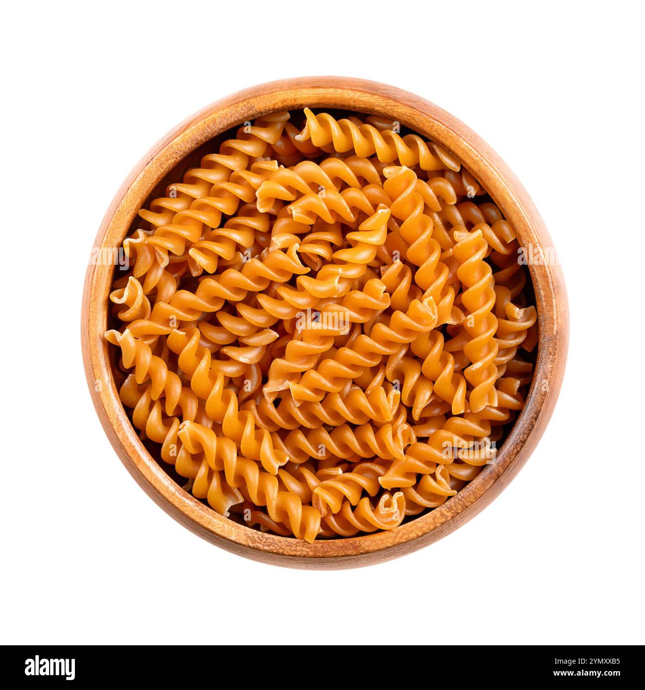 Pasta a spirale di ceci, spaghetti senza glutine in un recipiente di legno, isolato dall'alto. Piccoli fusilli, una varietà di pasta a forma elicoidale o cavatappi. Foto Stock
