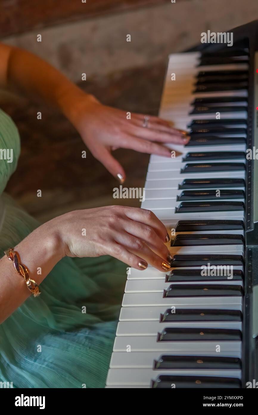 Primo piano di mani femminili che suonano con grazia il piano Foto Stock