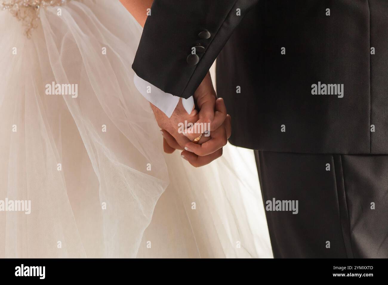 Matrimonio romantico: Sposa e sposo che si tengono per mano in un momento senza tempo Foto Stock