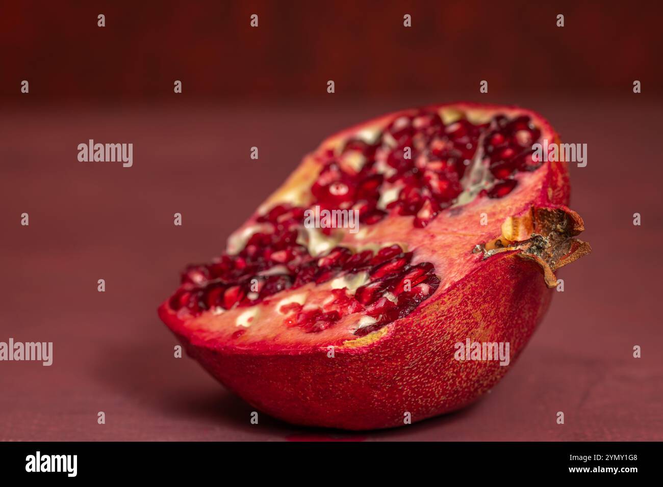 Frutta rossa di melograno fresca con sfondo rosso Foto Stock