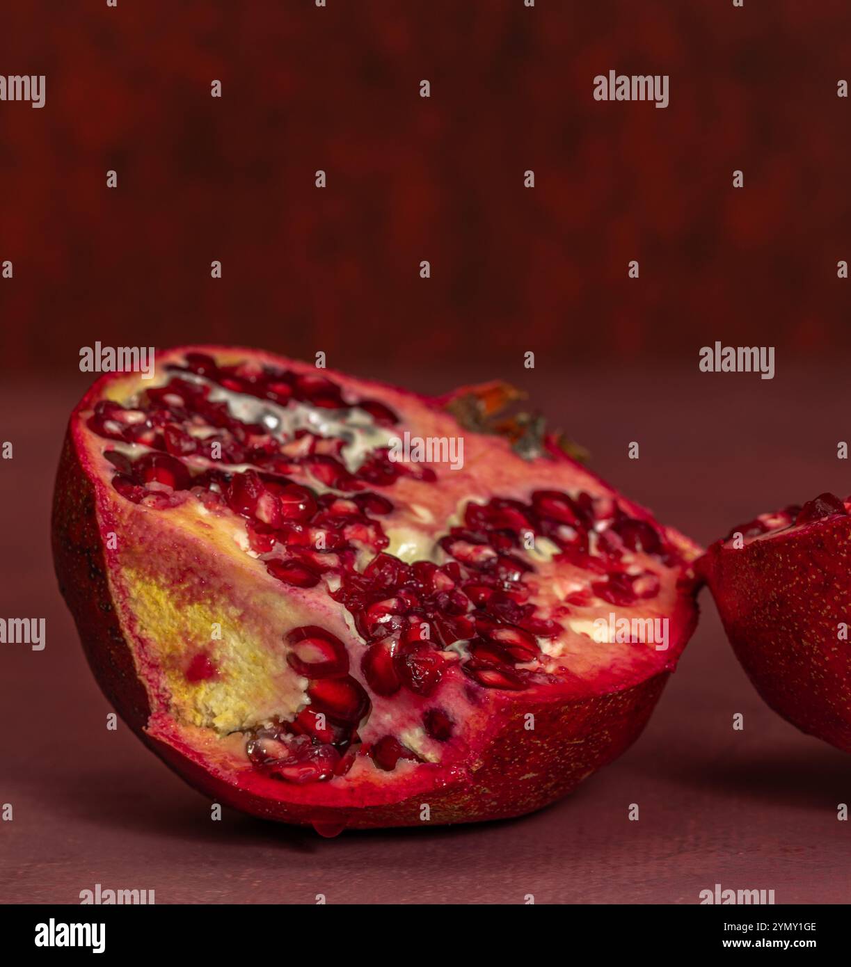 Frutta rossa di melograno fresca con sfondo rosso Foto Stock