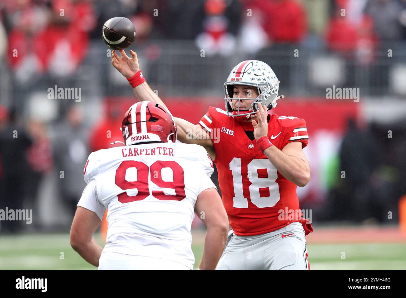 Columbus, Stati Uniti. 23 novembre 2024. Il quarterback degli Ohio State Buckeyes Will Howard (18) lancia gli Indian Hoosiers James Carpenter (99) nel primo quarto a Columbus, Ohio, sabato 23 novembre 2024. Foto di Aaron Josefczyk/UPI credito: UPI/Alamy Live News Foto Stock