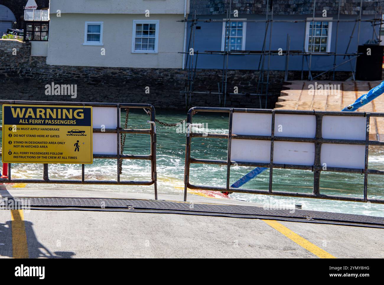Cartello di avvertimento per i passeggeri del traghetto su un molo con istruzioni di attenzione e sfondo di un traghetto inferiore della città portuale di Dartmouth Foto Stock