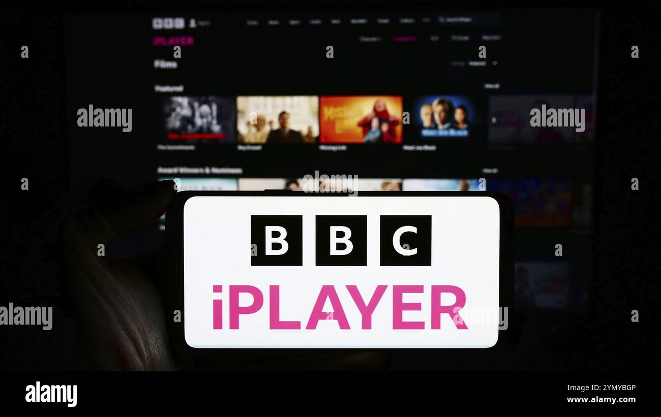 Stoccarda, Germania, 03-07-2024: Persona che tiene il cellulare con il logo del servizio britannico di video on demand BBC iPlayer davanti alla pagina web aziendale. Concentrati Foto Stock