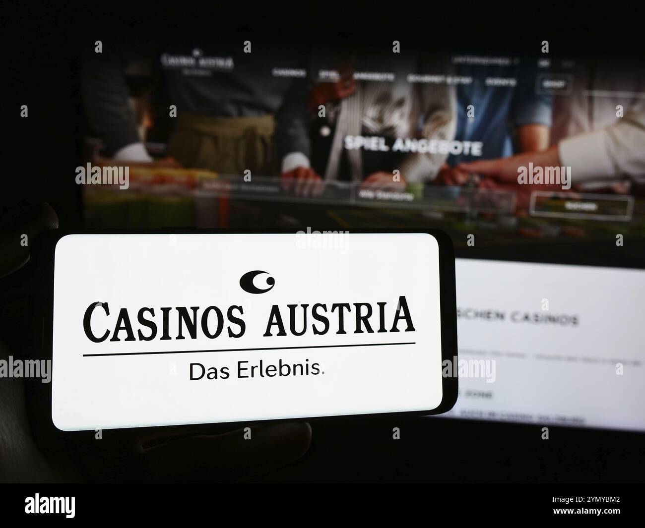 Stoccarda, Germania, 04-05-2024: Persona che possiede uno smartphone con il logo della società di gioco d'azzardo austriaca Casinos Austria AG davanti al sito web. Concentrati sul phon Foto Stock