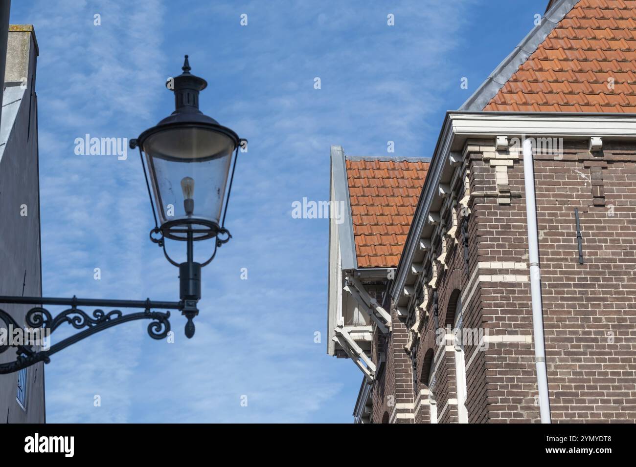 Facciata della vecchia casa con lampada da strada a muro Foto Stock