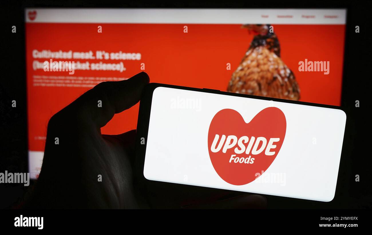 Stuttgart, Germania, 03-28-2024: Persona con smartphone con logo della società statunitense di carne coltivata upside Foods Inc. Davanti al sito Web. Concentrati sul telefono Foto Stock