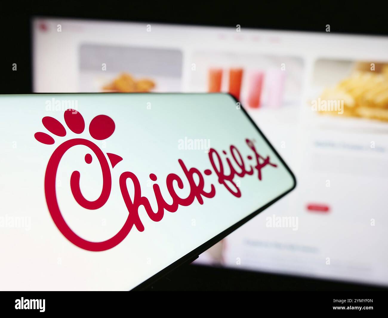 Stuttgart, Germania, 04-08-2024: Smartphone con logo della società americana di fast food Chick-fil-A Inc. Davanti al sito Web aziendale. Concentrati su Foto Stock