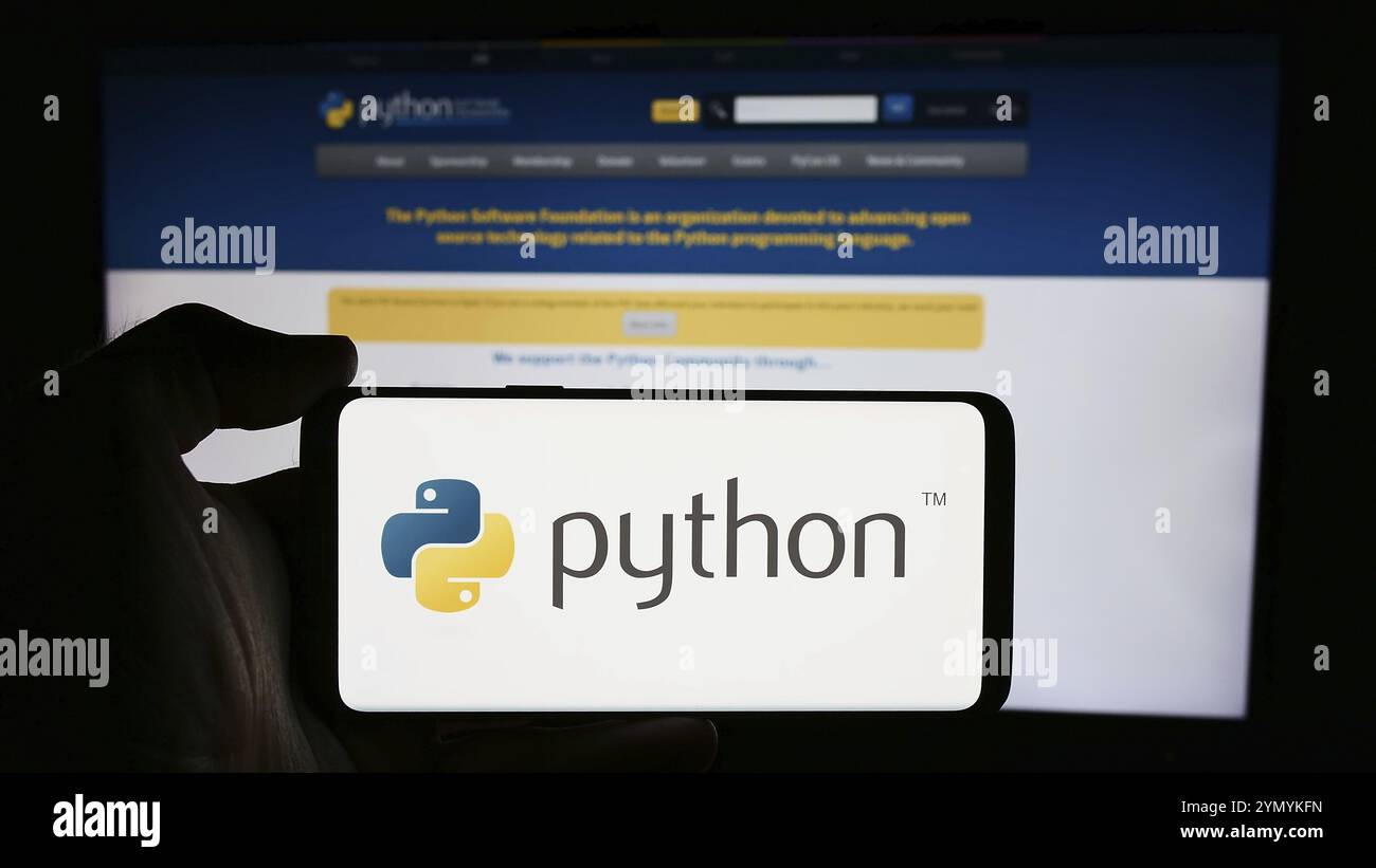 Stoccarda, Germania, 07-17-2024: Persona che tiene un cellulare con il logo dell'organizzazione Python software Foundation (PSF) davanti alla pagina web. Concentrati sul phon Foto Stock