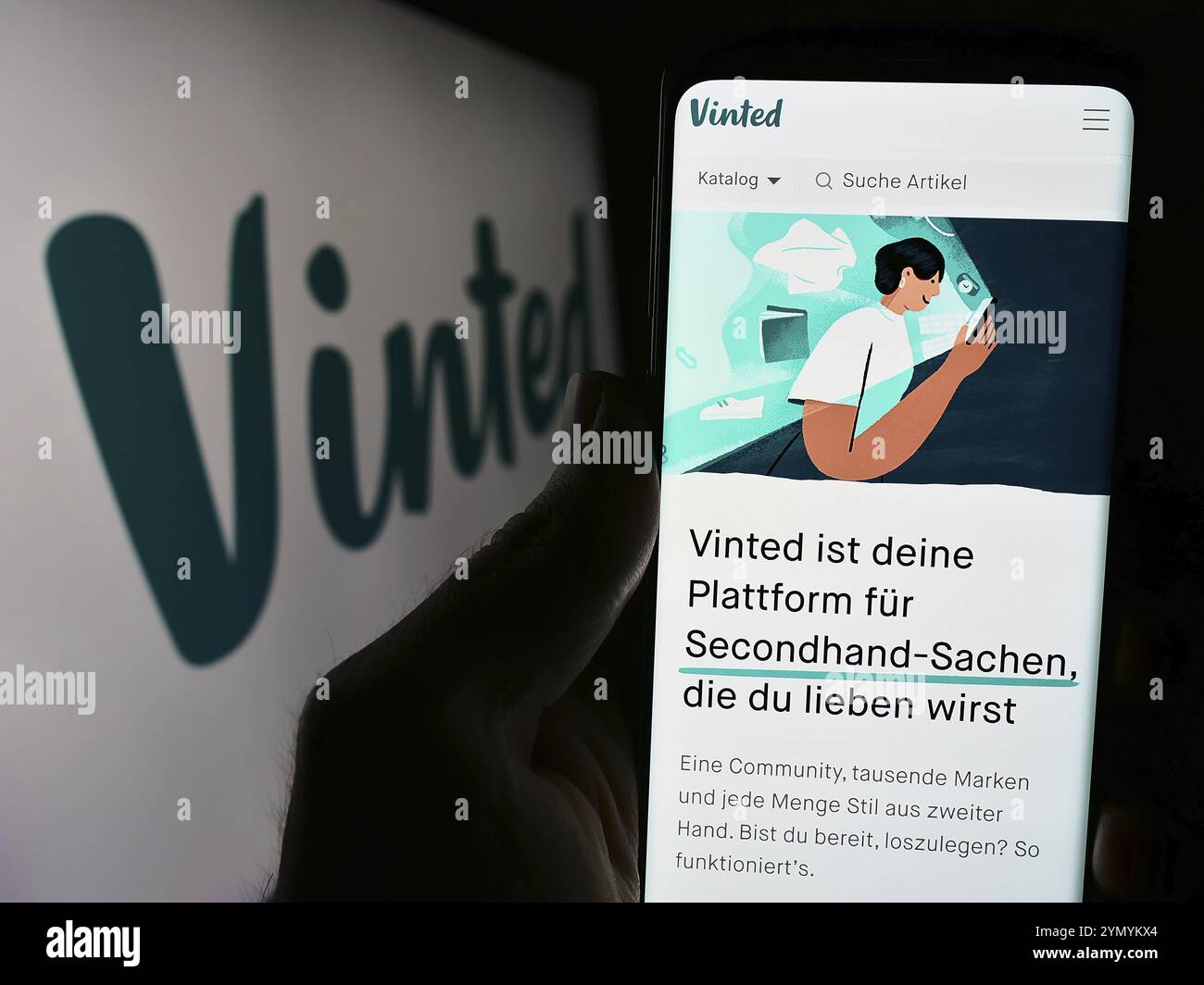 Stoccarda, Germania, 03-17-2024: Persona che detiene lo smartphone con pagina web della società di mercato di seconda mano online Vinted davanti al logo. Concentrati sul cent Foto Stock