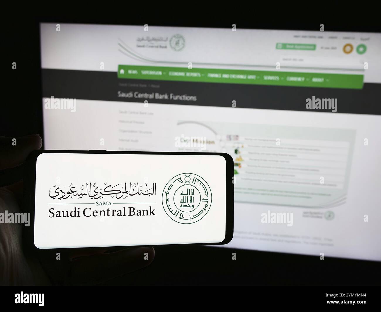 Stoccarda, Germania, 06-14-2024: Persona con smartphone con logo dell'istituto finanziario Saudi Central Bank (SAMA) davanti al sito web. Concentrati su p Foto Stock