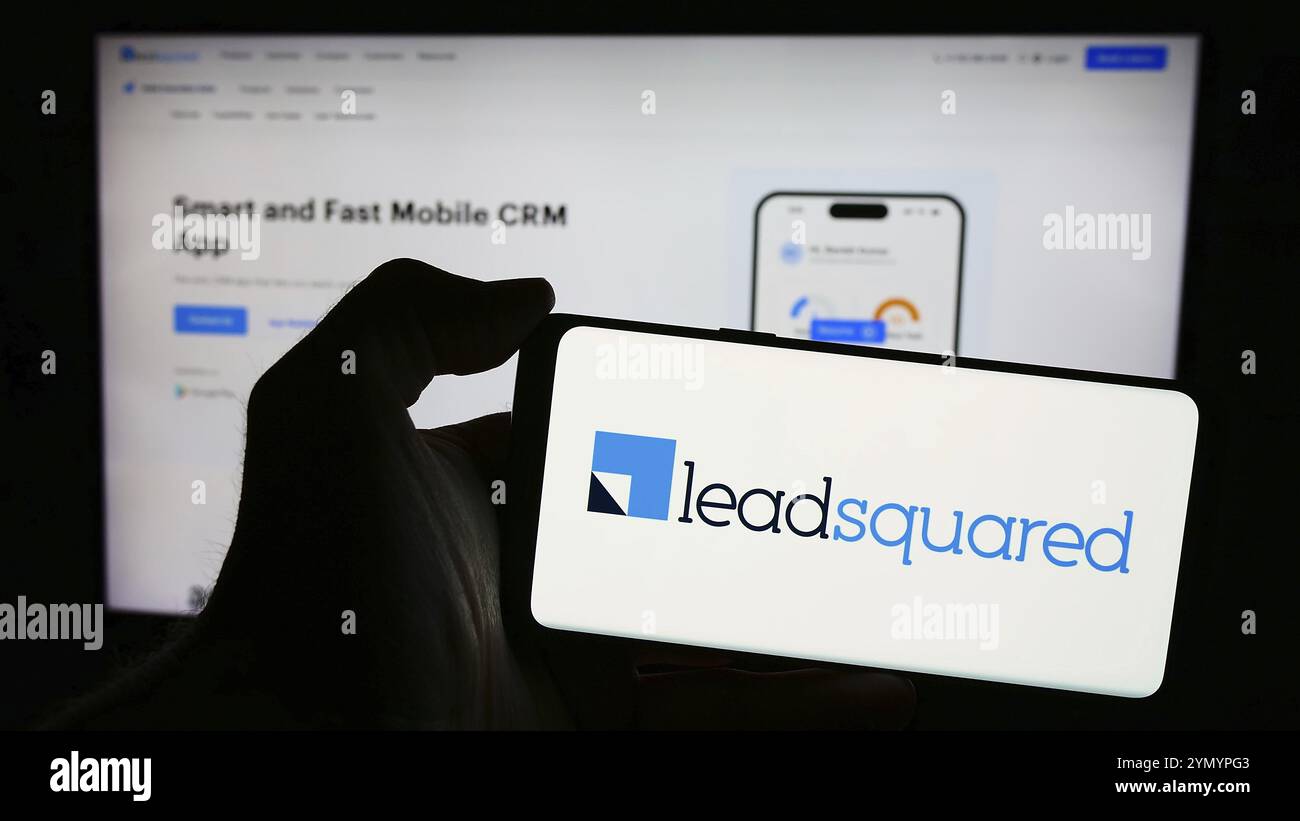 Stoccarda, Germania, 03-27-2024: Persona che detiene un telefono cellulare con il logo della società indiana di piattaforme CRM LeadSquared di fronte alla pagina web aziendale. Concentrati Foto Stock