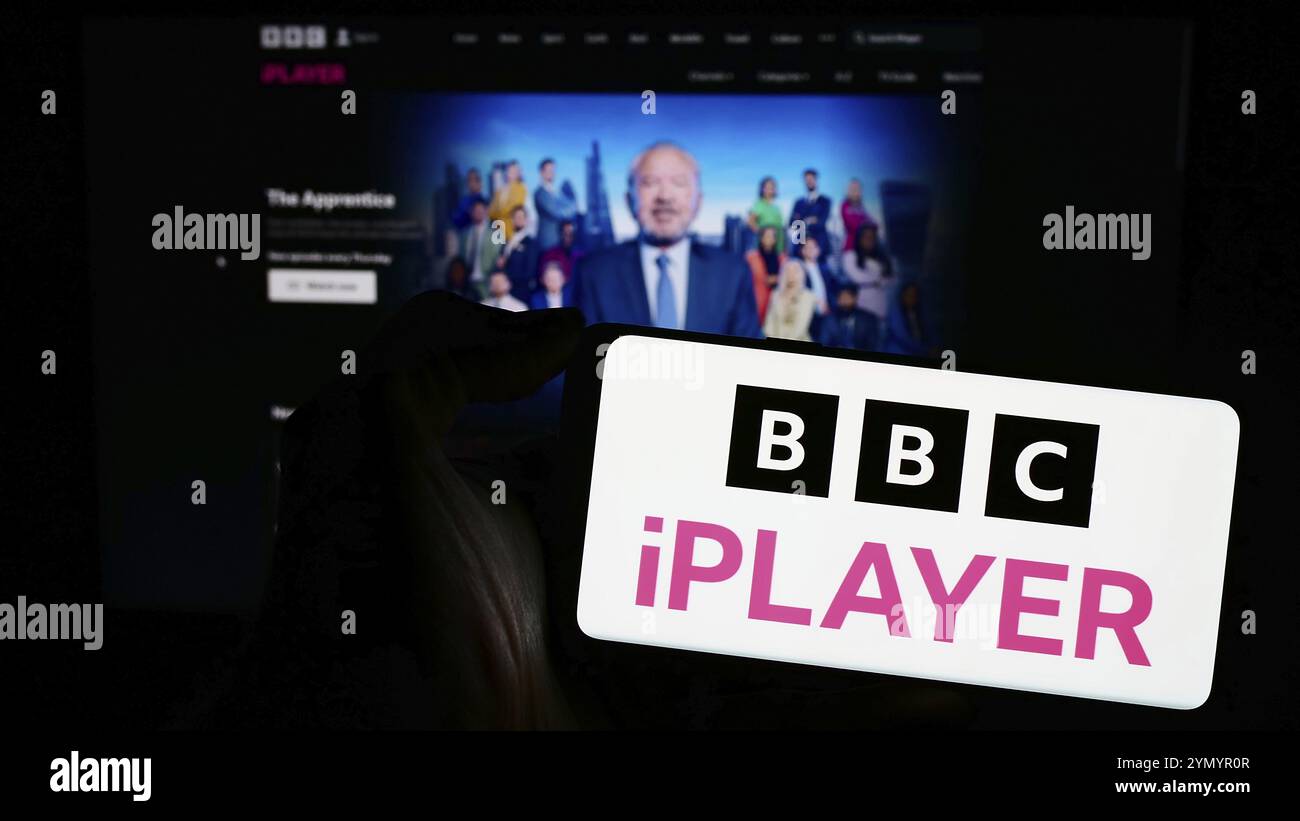 Stoccarda, Germania, 03-07-2024: Persona che detiene un telefono cellulare con logo del servizio britannico di video on demand BBC iPlayer davanti alla pagina web dell'azienda. FOC Foto Stock