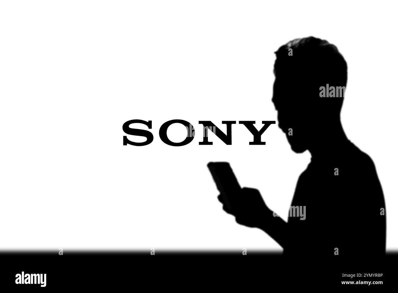 SONY è una società giapponese. SONY è un'azienda produttrice di console di videogiochi e di videogiochi. Smartphone con logo SONY sullo schermo circondato da gamepad. Foto Stock