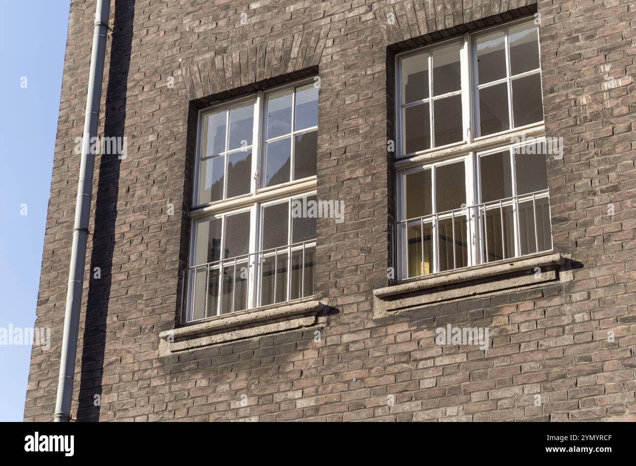 Facciata di un vecchio edificio in mattoni con finestre Foto Stock