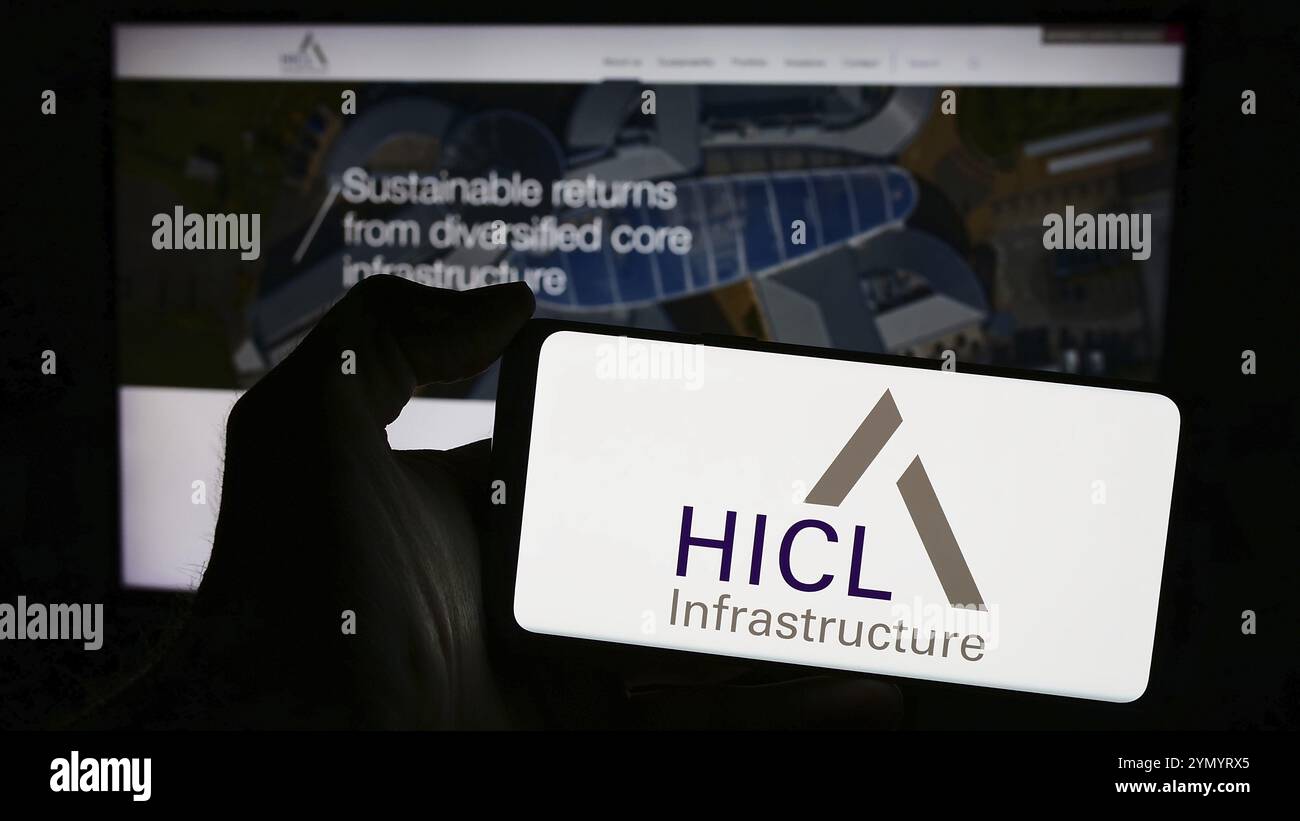Stoccarda, Germania, 03-20-2024: Persona che detiene il cellulare con il logo della società di investimento britannica HICL Infrastructure davanti alla pagina web aziendale. FOC Foto Stock