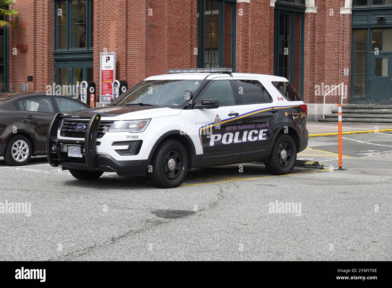 Un'auto della polizia di transito della Metro Vancouver parcheggiata fuori da un edificio di mattoni rossi a Vancouver, B. C., Canada. Foto Stock