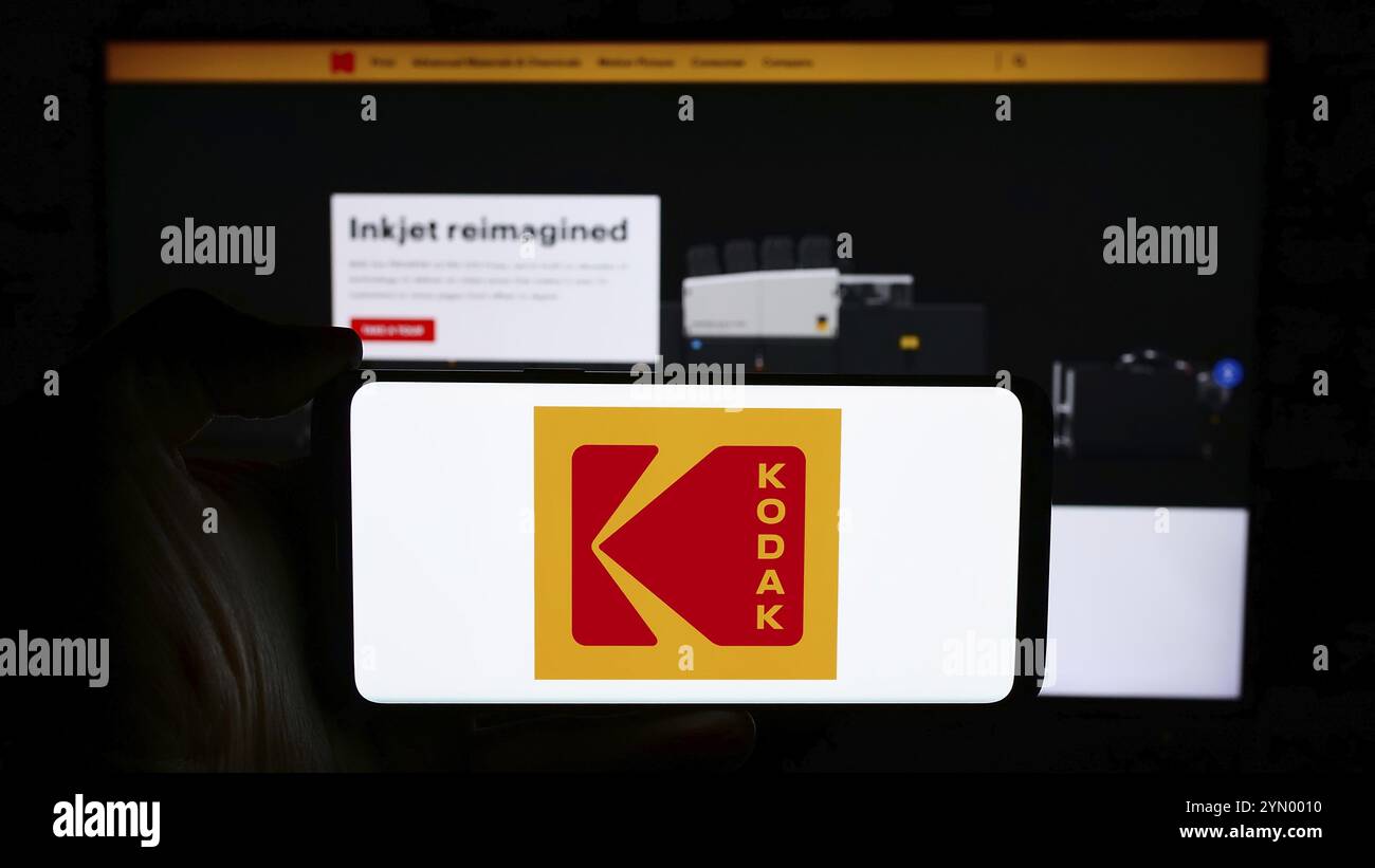 Stoccarda, Germania, 04-17-2024: Persona che detiene il cellulare con il logo dell'azienda statunitense di elettronica Eastman Kodak Company di fronte alla pagina web aziendale. Focu Foto Stock