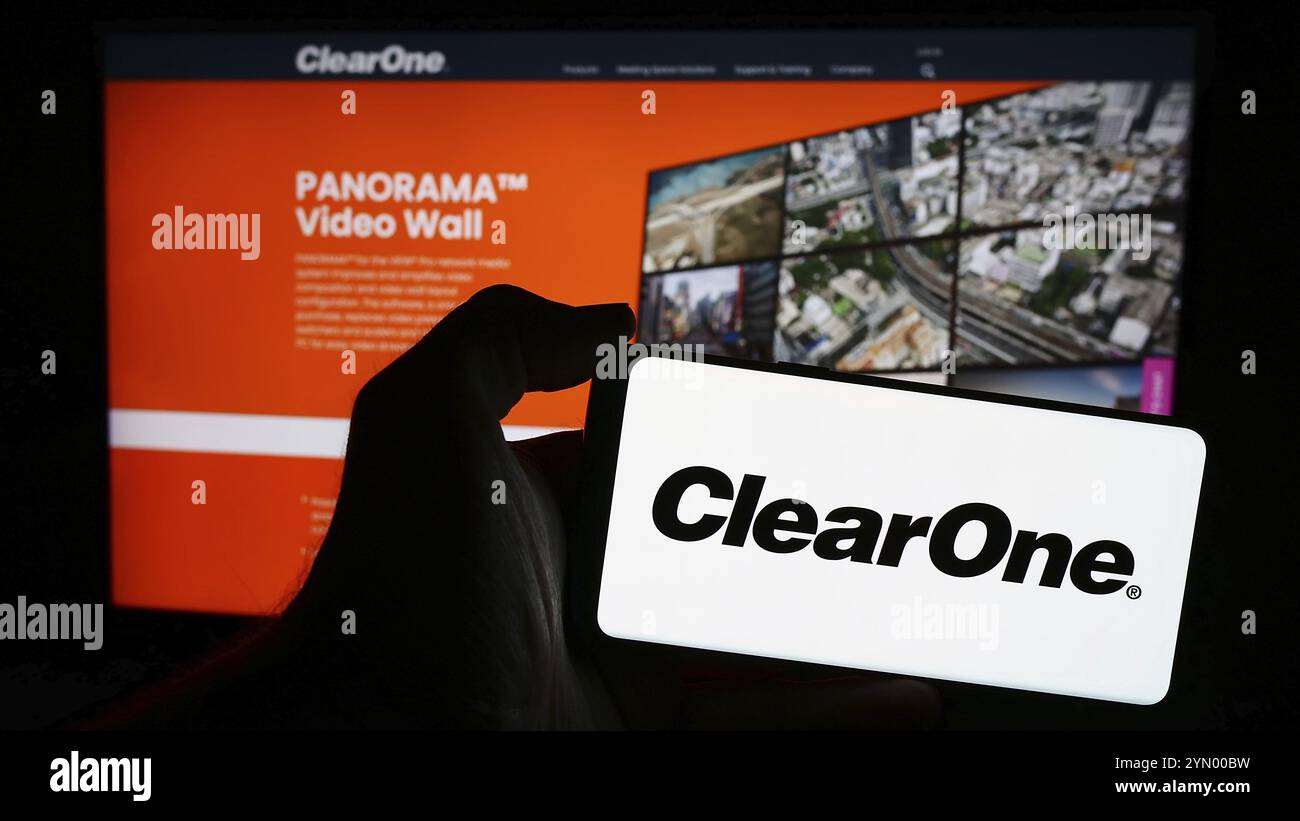 Stoccarda, Germania, 05-06-2024: Persona che detiene un telefono cellulare con il logo della società americana di soluzioni per conferenze ClearOne Inc. Davanti alla pagina web. F Foto Stock