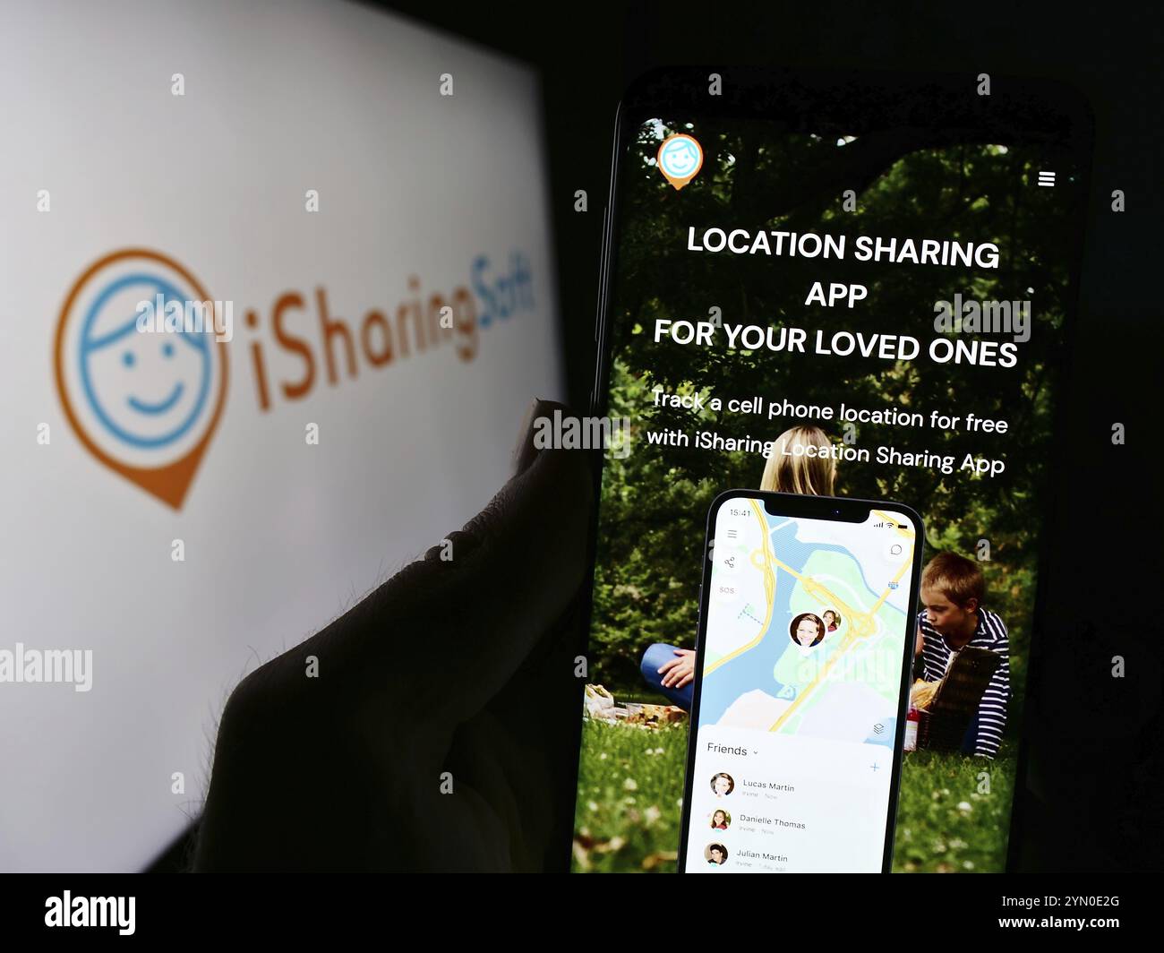 Stoccarda, Germania, 02-24-2024: Persona che detiene il cellulare con pagina web della società di social mapping statunitense iSharingSoft Inc. (ISharing) con logo. Concentratevi su ce Foto Stock