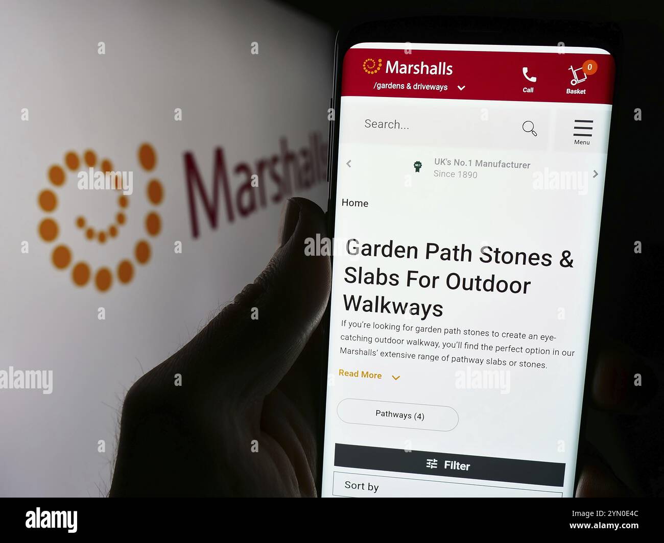 Stoccarda, Germania, 03-25-2024: Persona che tiene il cellulare con pagina web della società britannica di prodotti paesaggistici Marshalls plc davanti al logo. Concentrati su Foto Stock