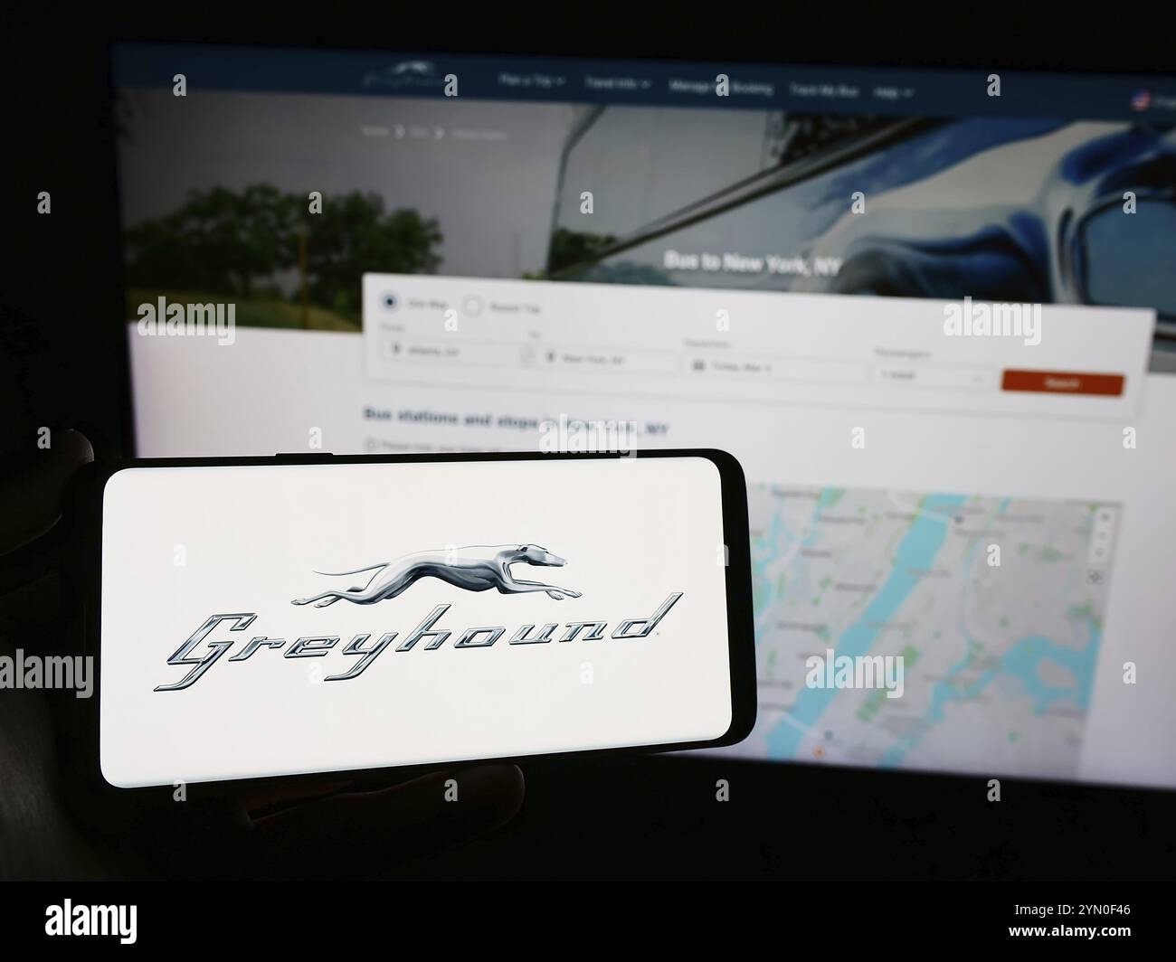 Stoccarda, Germania, 03-05-2024: Persona con smartphone con logo della compagnia di autobus a lunga percorrenza Greyhound Lines Inc. Davanti al sito web. Concentrati su Foto Stock