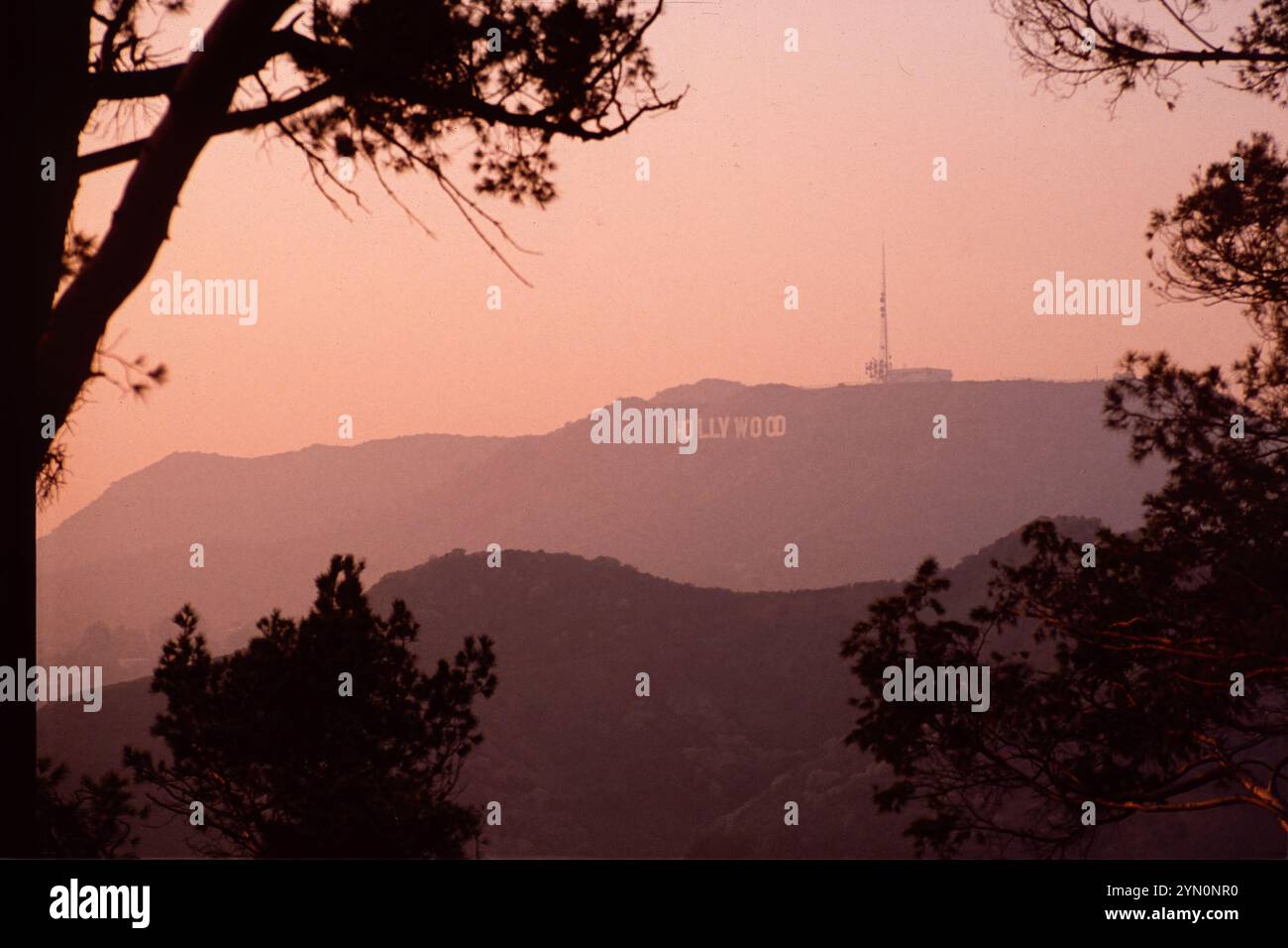 L'insegna di Hollywood vista dal Griffith Park al crepuscolo attraverso lo smog di Los Angeles degli anni '1980 Los Angeles ha sperimentato alcuni dei peggiori smog nel 1988, quando questa foto è stata scattata. In effetti, il 1988 è stato il terzo anno peggiore per lo smog - dopo il 1981 e il 1984 - del decennio, secondo le relazioni ufficiali sulla qualità dell'aria dell'epoca. Foto Stock