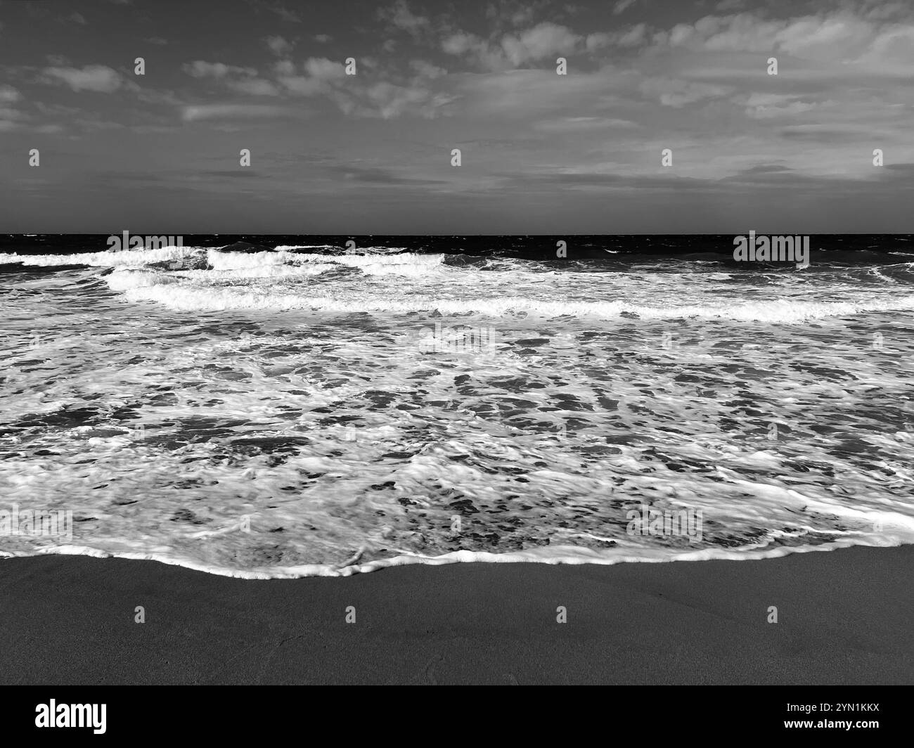 Onde drammatiche su una spiaggia tempestosa catturate con una fotografia straordinaria, perfetta per gli appassionati d'arte Foto Stock