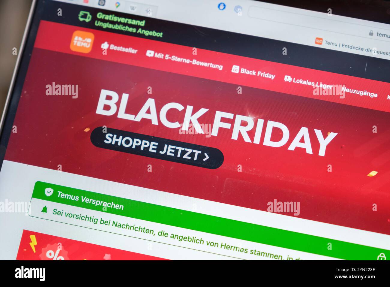 Black Friday. Mano che tiene un telefono cellulare che mostra il sito web della società cinese Temu Foto Stock