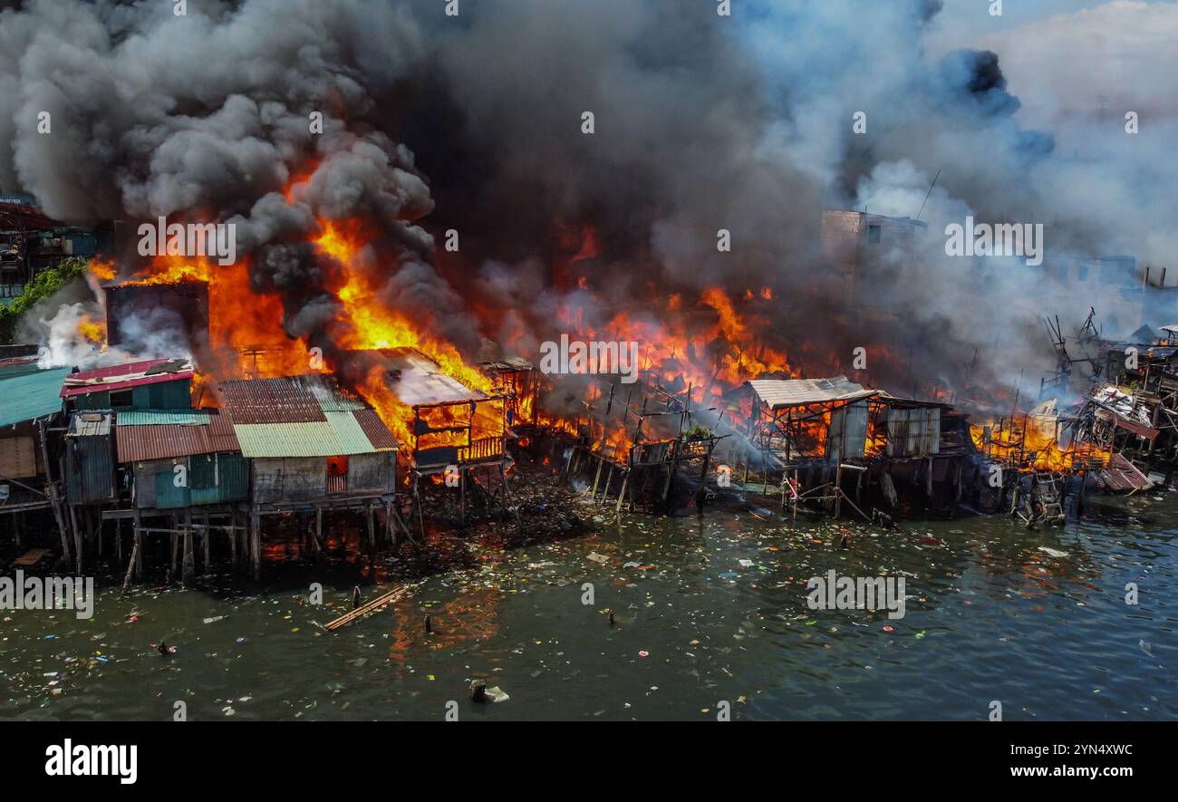 Manila. 24 novembre 2024. Una foto con un drone mostra un incendio che inghiottisce un'area di slum a Manila, nelle Filippine, il 24 novembre 2024. Crediti: Rouelle Umali/Xinhua/Alamy Live News Foto Stock