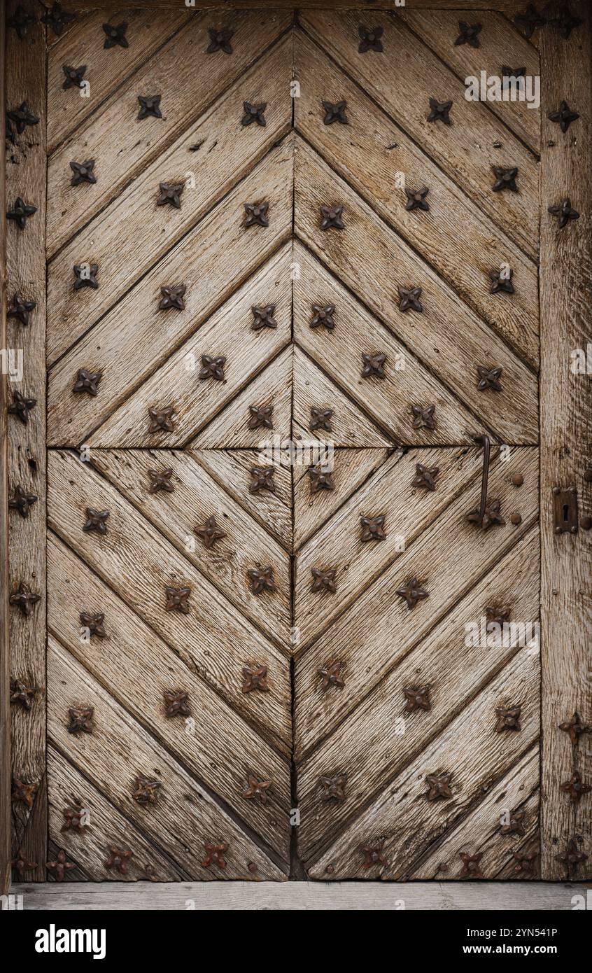 Dettaglio di porte in legno molto vecchie con ornamenti metallici Foto Stock