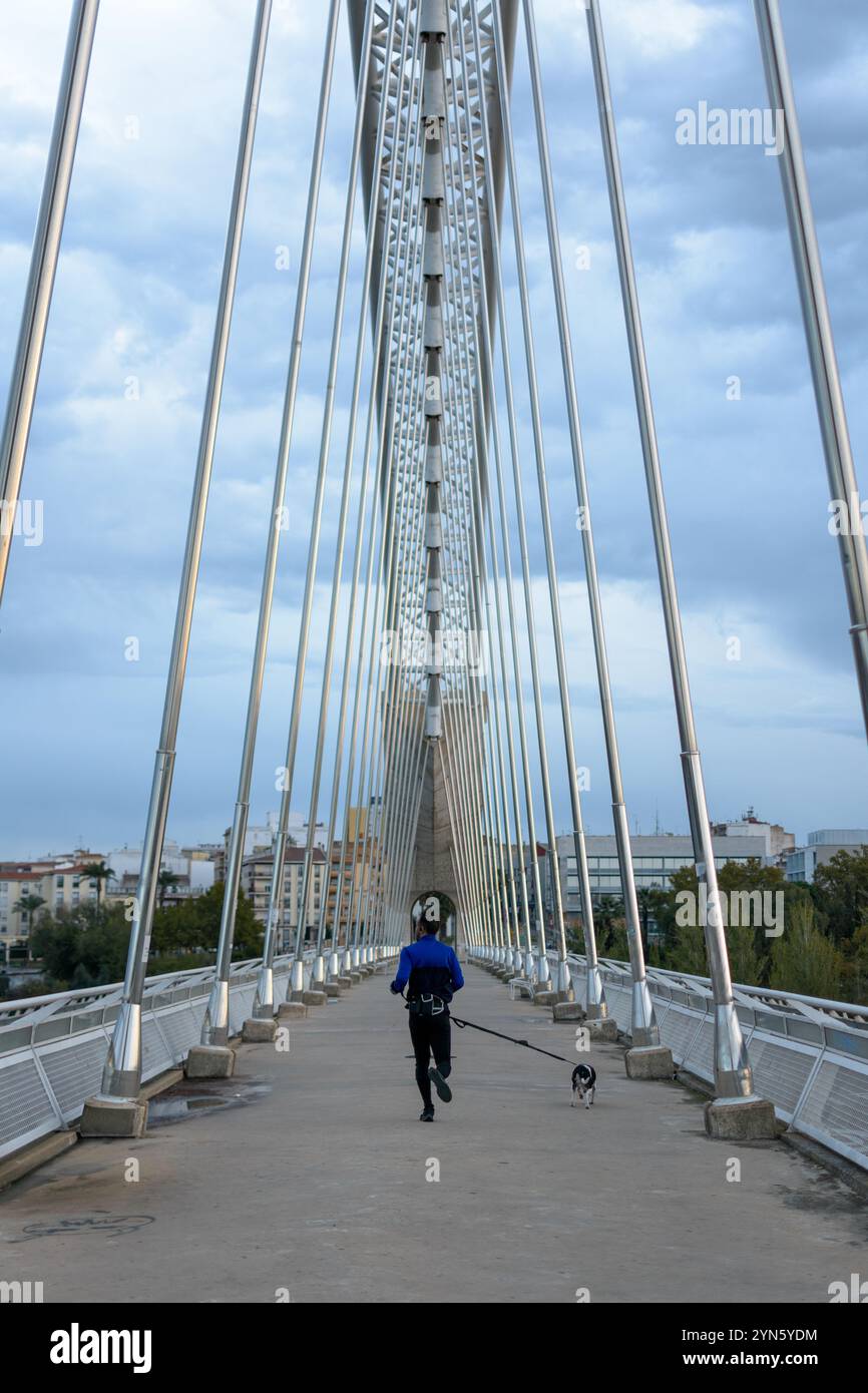 uomo che si allena con il suo cane sul ponte cittadino. Foto Stock