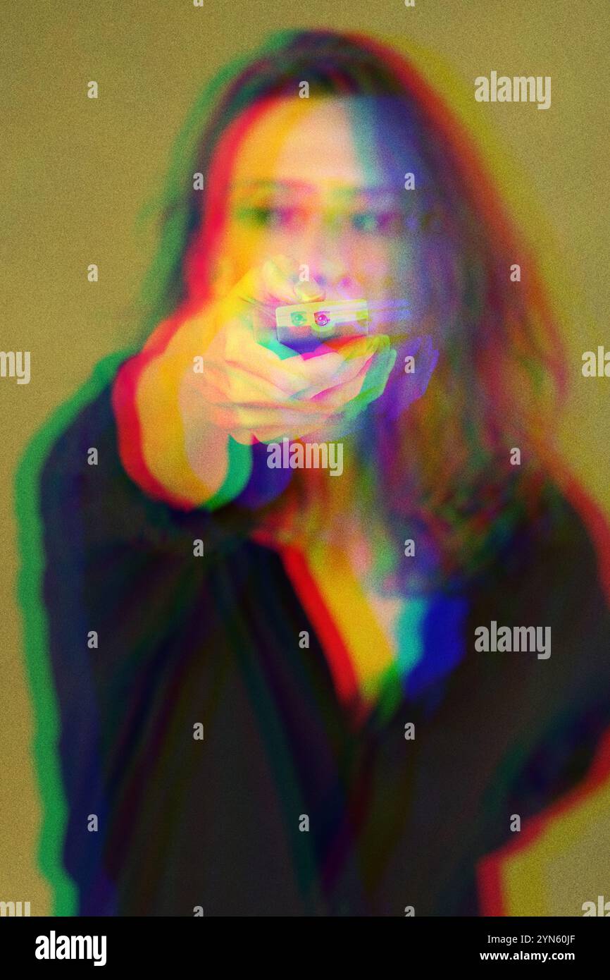 Tecnologia, televisione e media. Una giovane donna con un telecomando mirata in avanti. Effetto glitch digitale applicato in rosso, verde e blu colo Foto Stock