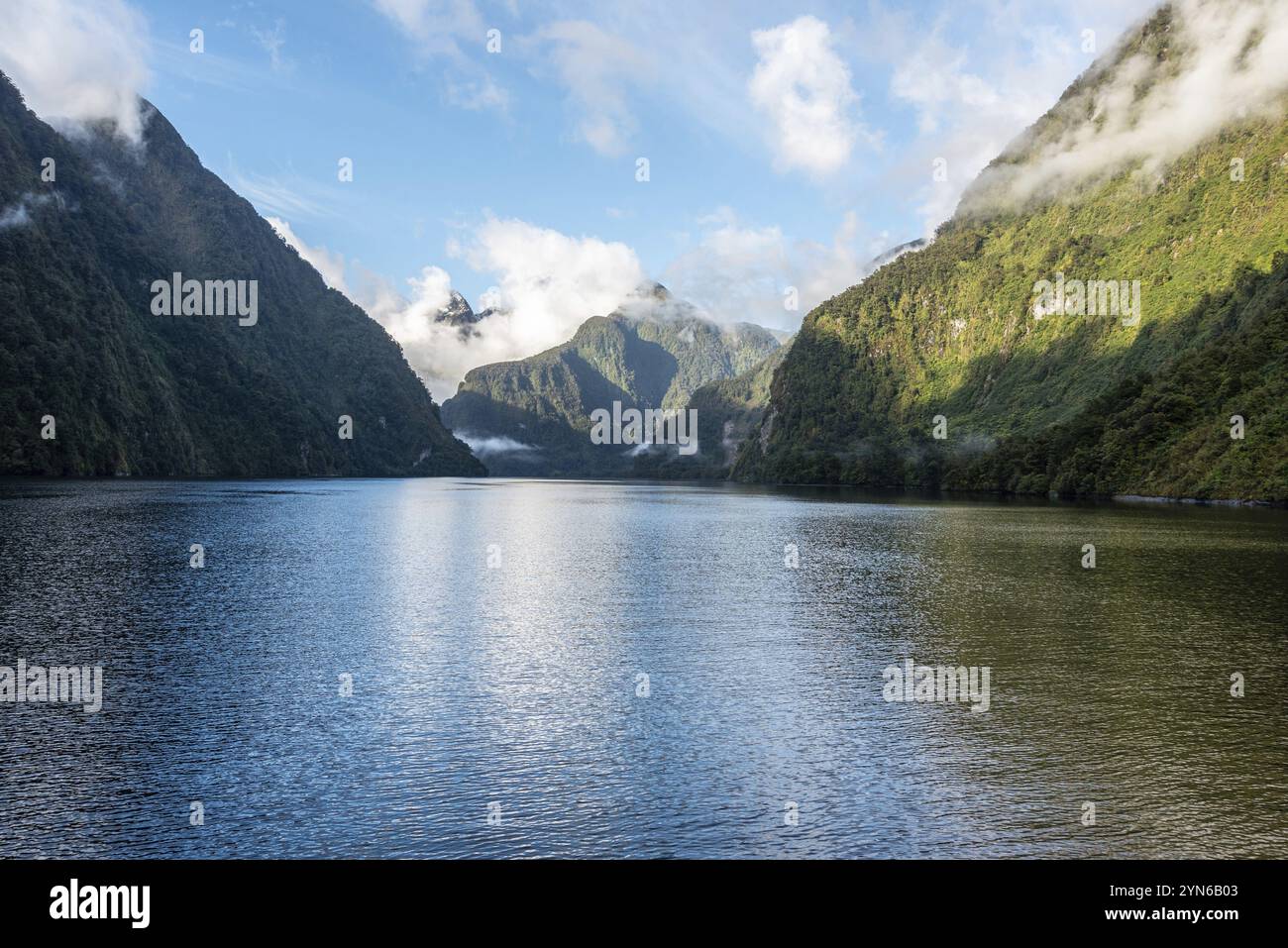 Una nuova mattina che si innamora a Doutful Sound, nuvole che pendono in basso nelle montagne, Isola del Sud della Nuova Zelanda Foto Stock