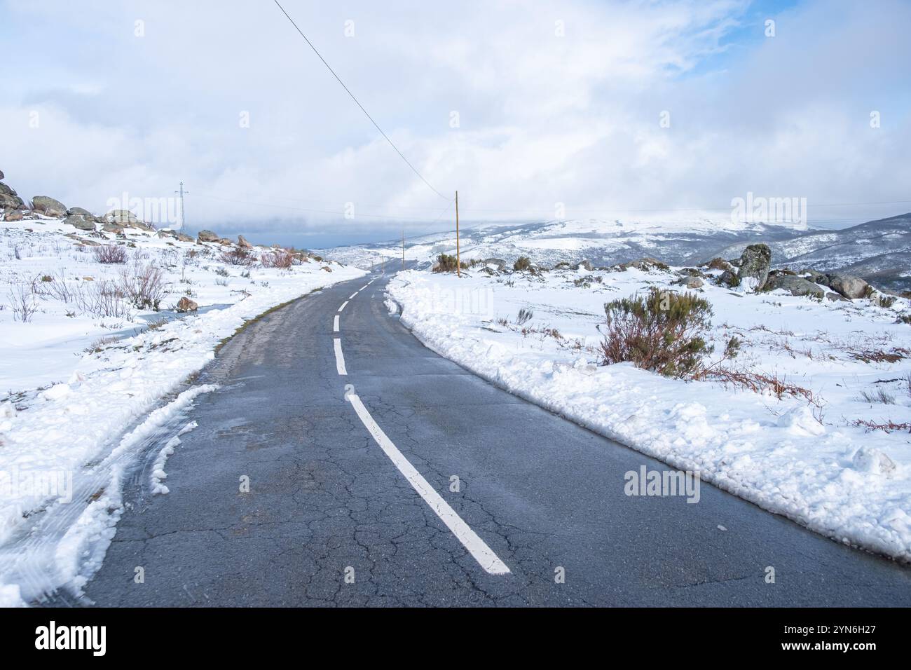 strada senza traffico in un paesaggio montano invernale innevato Foto Stock