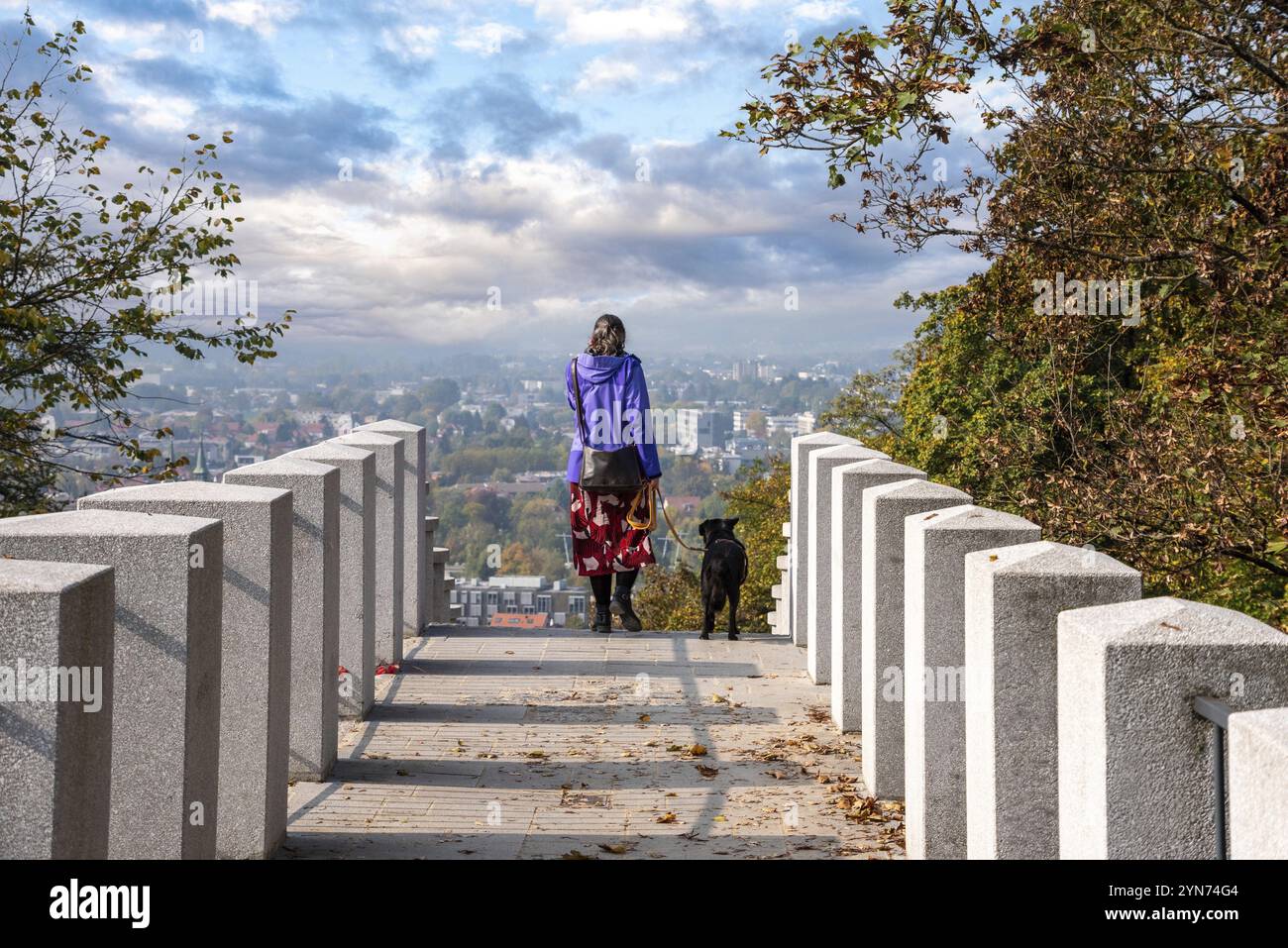 Una donna che cammina con il suo cane nel parco del castello di Lubiana, capitale della Slovenia Foto Stock