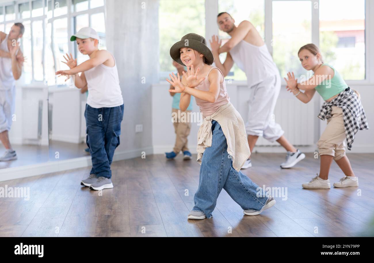 Un gruppo di bambini in abiti casual si sta allenando insieme per ballare hip-hop e breakdance nel centro di danza Foto Stock