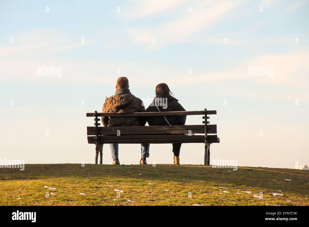 Una coppia innamorata su una panchina di legno in cima alla collina godendo della vista di Belgrado Foto Stock