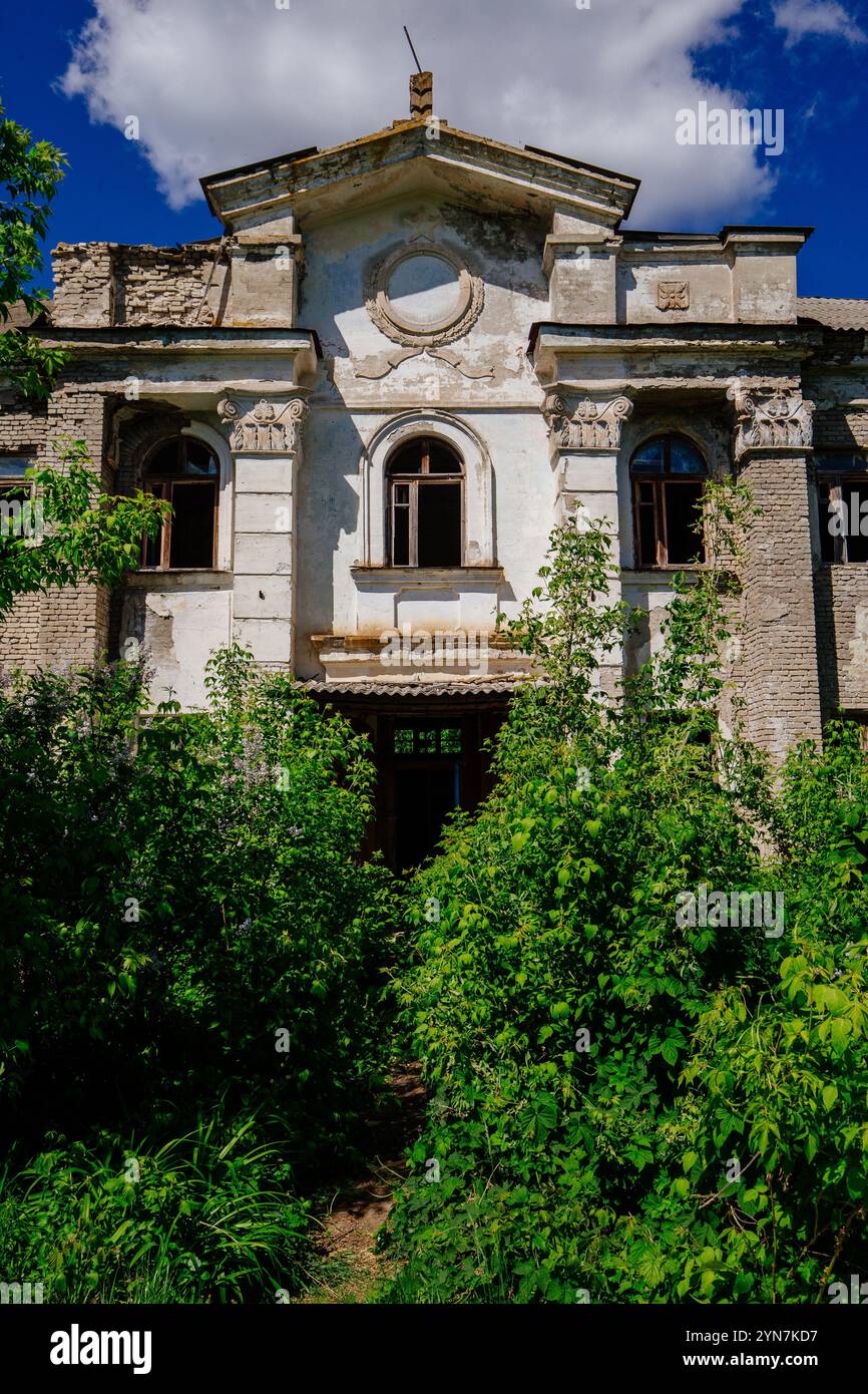 Vecchio edificio abbandonato, ricoperto di piante. Foto Stock