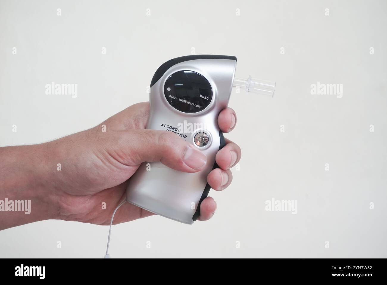 Rilevatore analizzatore di respirazione ad alcool Man Holding Digital Breathalyzer. Per misurare il contenuto alcolico nel sangue non bere e guidare il concetto con il seno Foto Stock