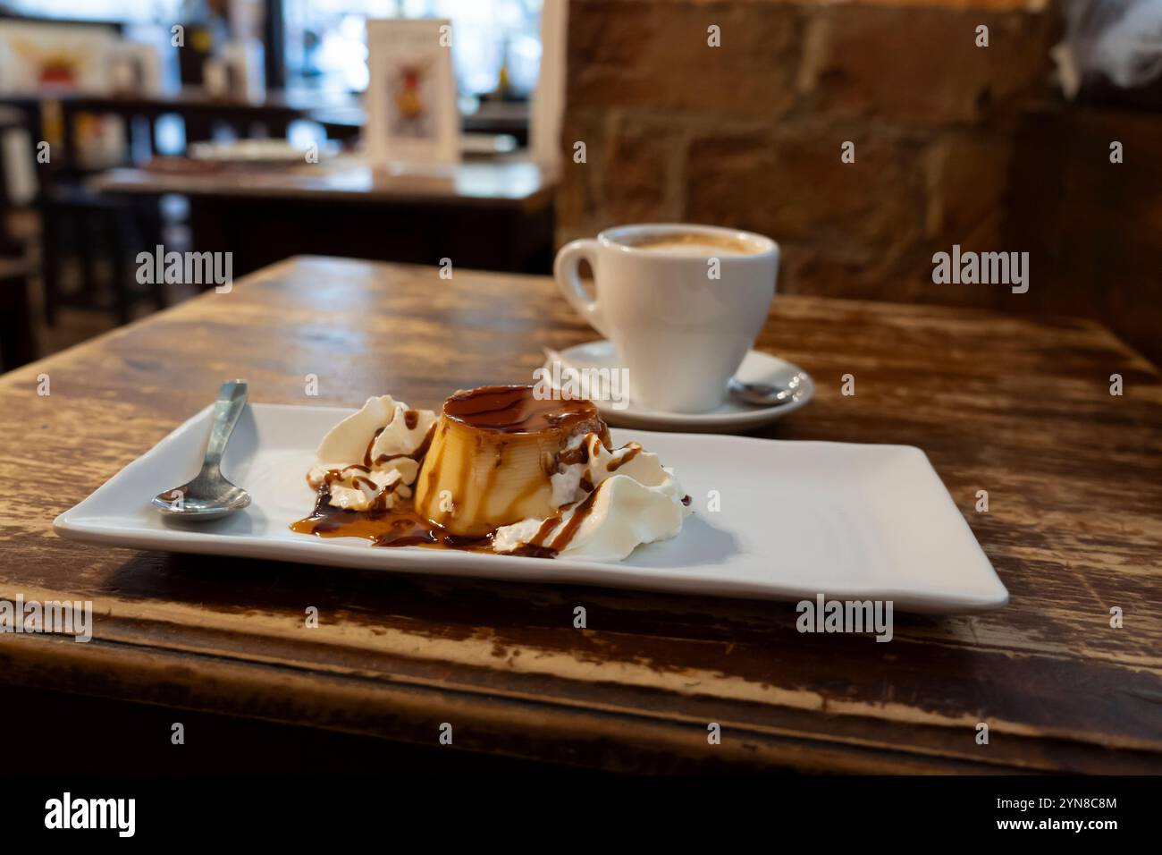 Un tradizionale flan e caffetteria con leche servito a Taberna la Tía Cebolla nel Barrio de las Letras a Madrid, Spagna. Foto Stock