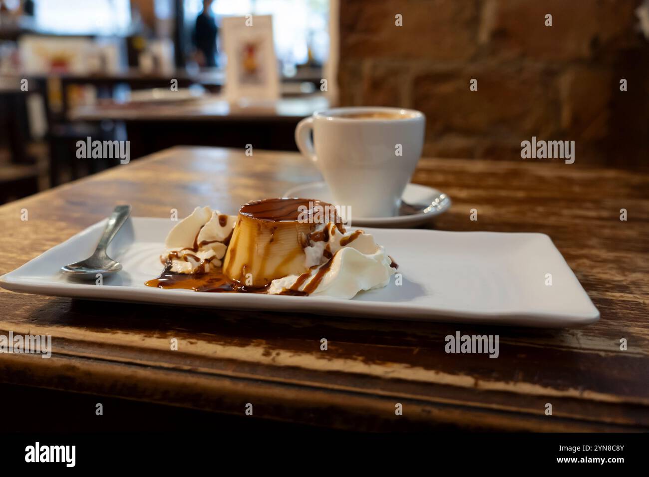 Un tradizionale flan e caffetteria con leche servito a Taberna la Tía Cebolla nel Barrio de las Letras a Madrid, Spagna. Foto Stock