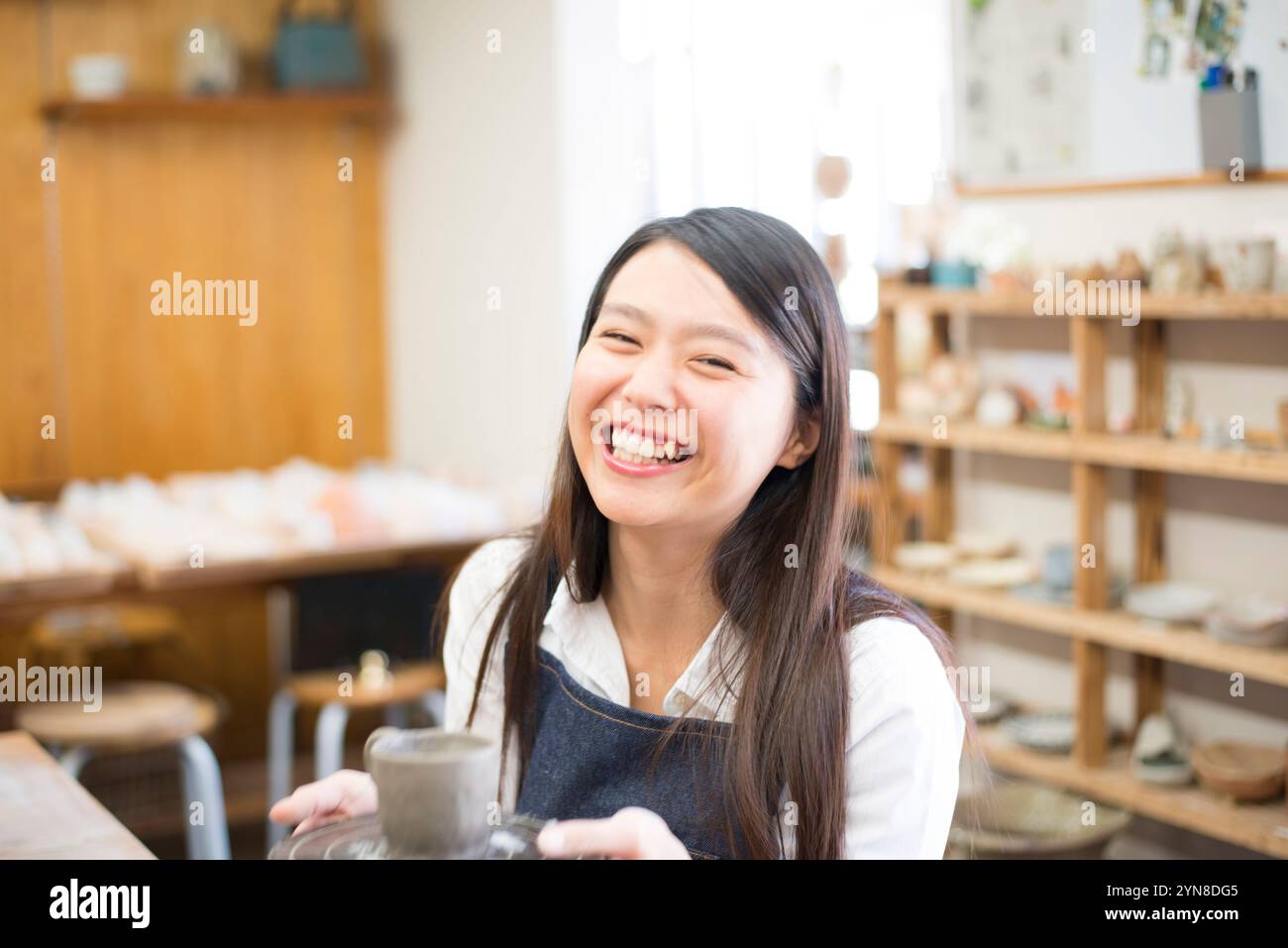 Donna sorridente con il suo lavoro in classe di ceramica Foto Stock