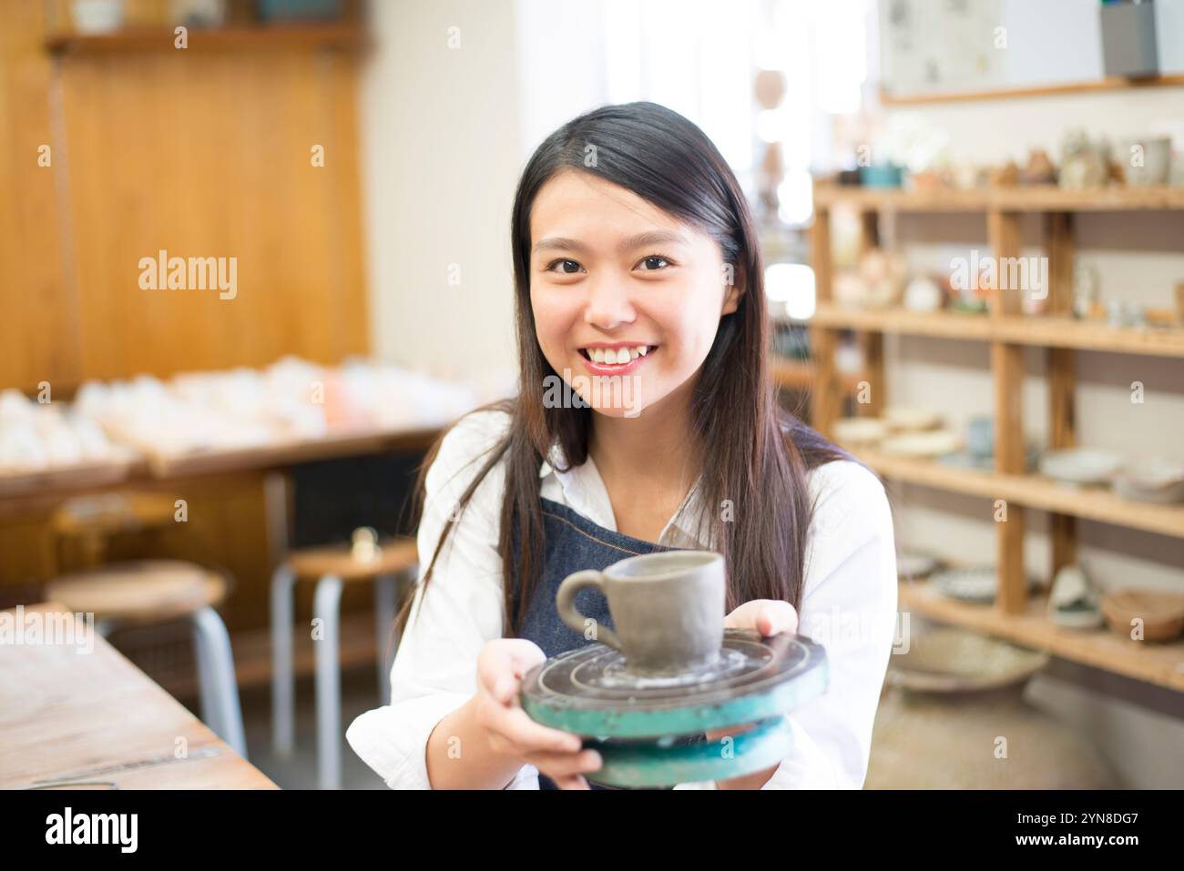 Donna sorridente con il suo lavoro in classe di ceramica Foto Stock