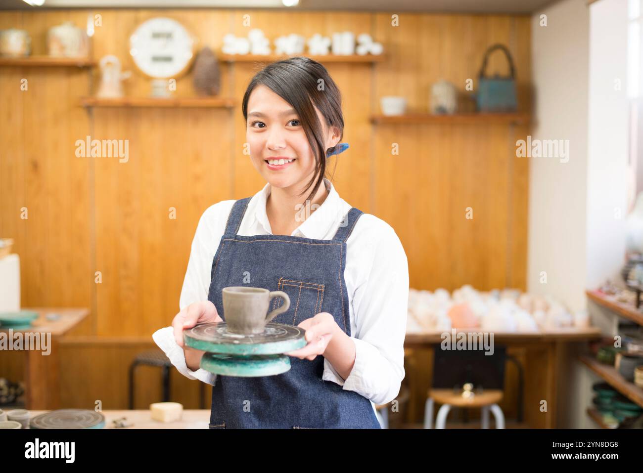 Donna sorridente con il suo lavoro in classe di ceramica Foto Stock