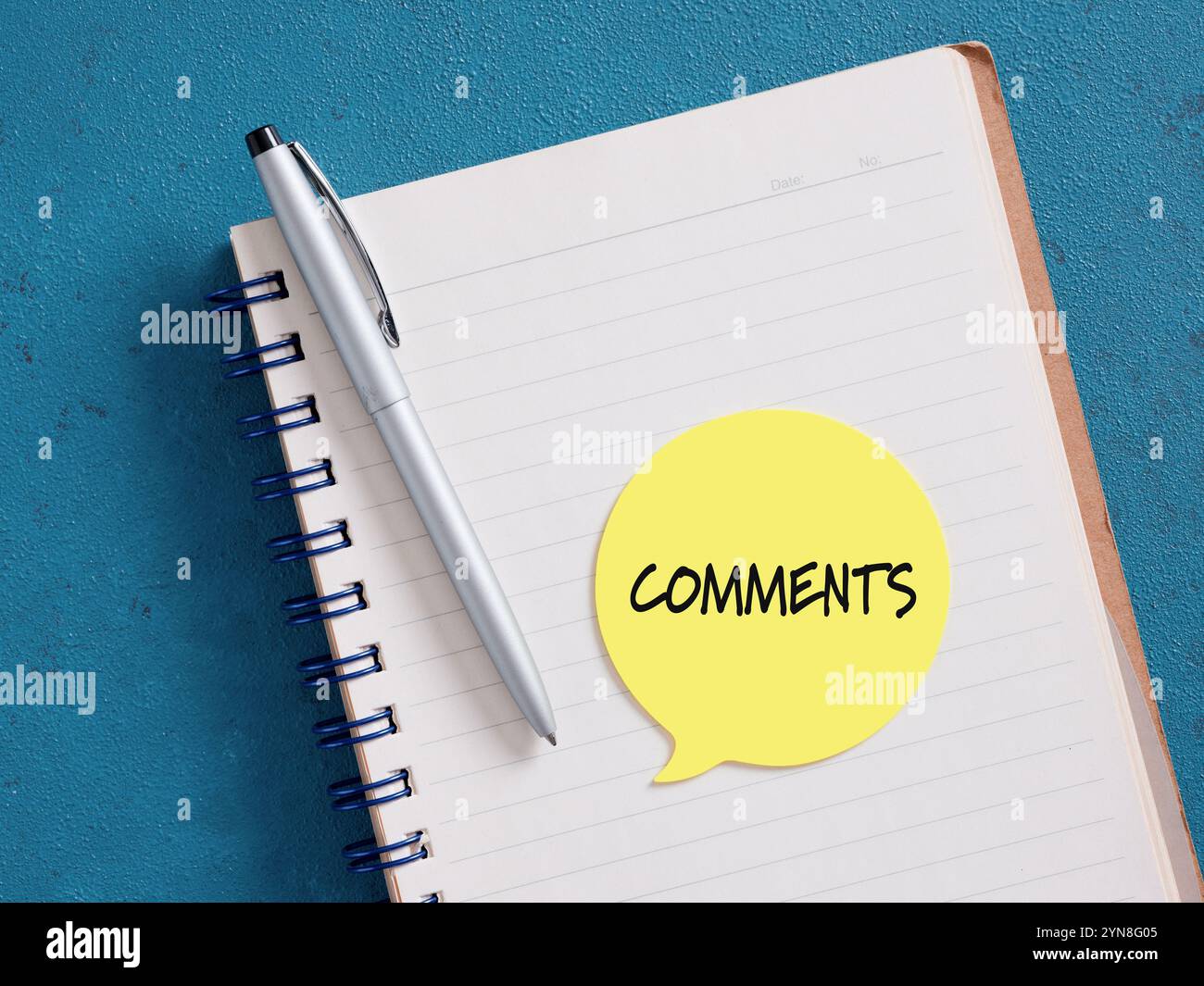 Pagina di blocco note con commenti scritti su una nota adesiva con una penna, suggerendo di fornire feedback o condividere pensieri Foto Stock