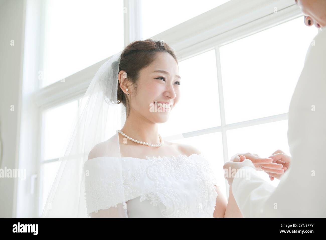 Sposa sorridente e sposo durante lo scambio degli anelli Foto Stock