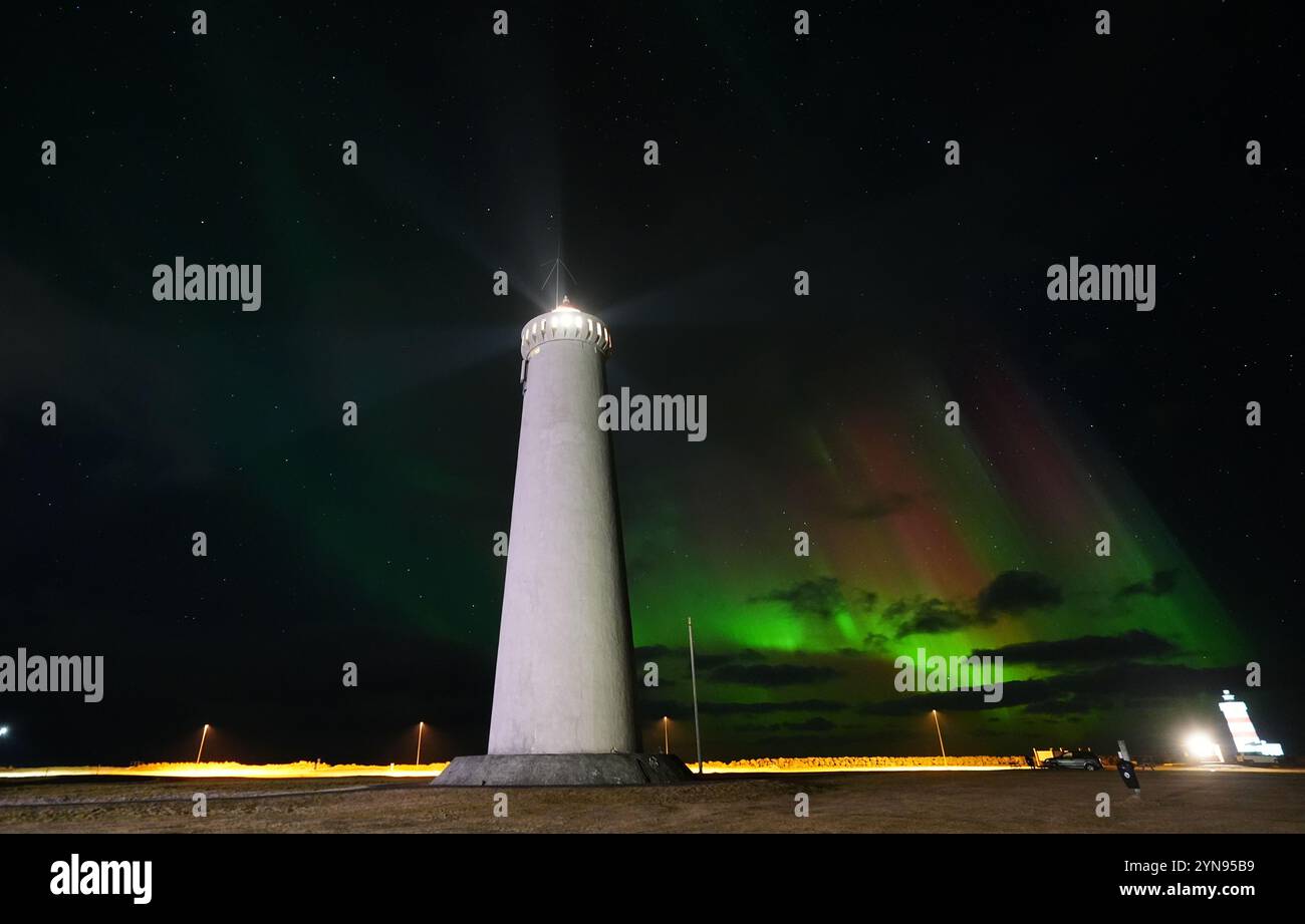 L'aurora boreale, nota anche come aurora boreale, visibile sopra il faro di New Gardur, builit nel 1944 sul punto settentrionale della penisola di Reykjanes in Islanda. Data foto: Domenica 24 novembre 2024. Foto Stock